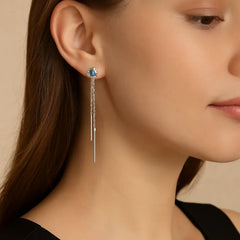 Close-up of woman wearing blue moissanite sterling silver chain drop earrings