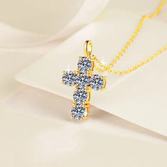 Gold cross pendant necklace on a beige background