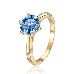 Gold ring with a blue gemstone on a white background