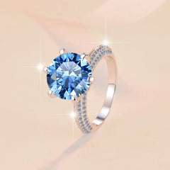 Ring with a large blue gemstone on a beige background