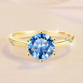 Gold ring with a blue gemstone on a beige background