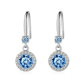 Pair of silver earrings with blue gemstones on a white background