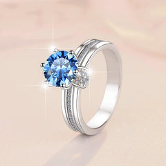 Silver ring with a blue gemstone on a light background