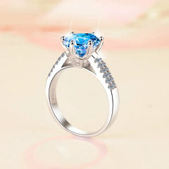 Silver ring with a blue gemstone on a soft, blurred background