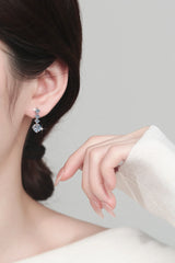 Close-up of a woman wearing certified moissanite chandelier earrings in sterling silver with sparkling white stones