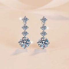 Pair of diamond earrings on a beige background