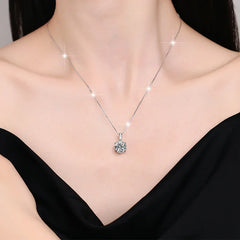 Silver necklace with a pendant on a model wearing a black top