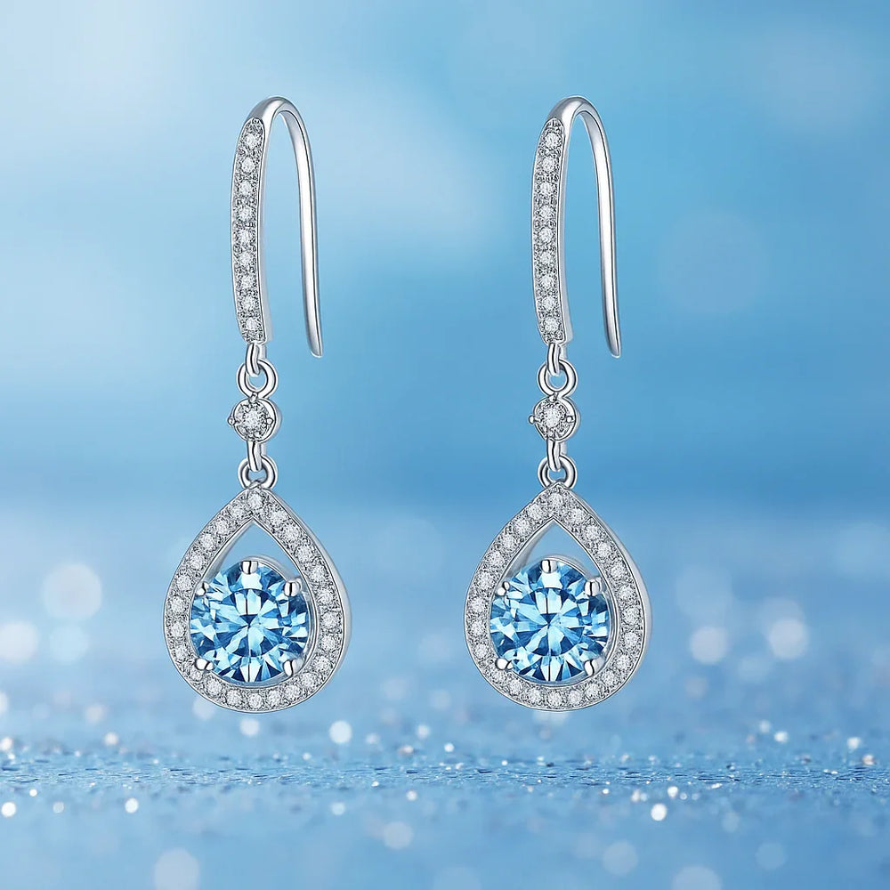 Teardrop-shaped earrings with blue gemstones on a blue background