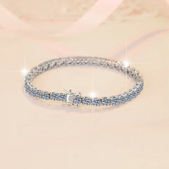 Silver bracelet with clear stones on a light pink background