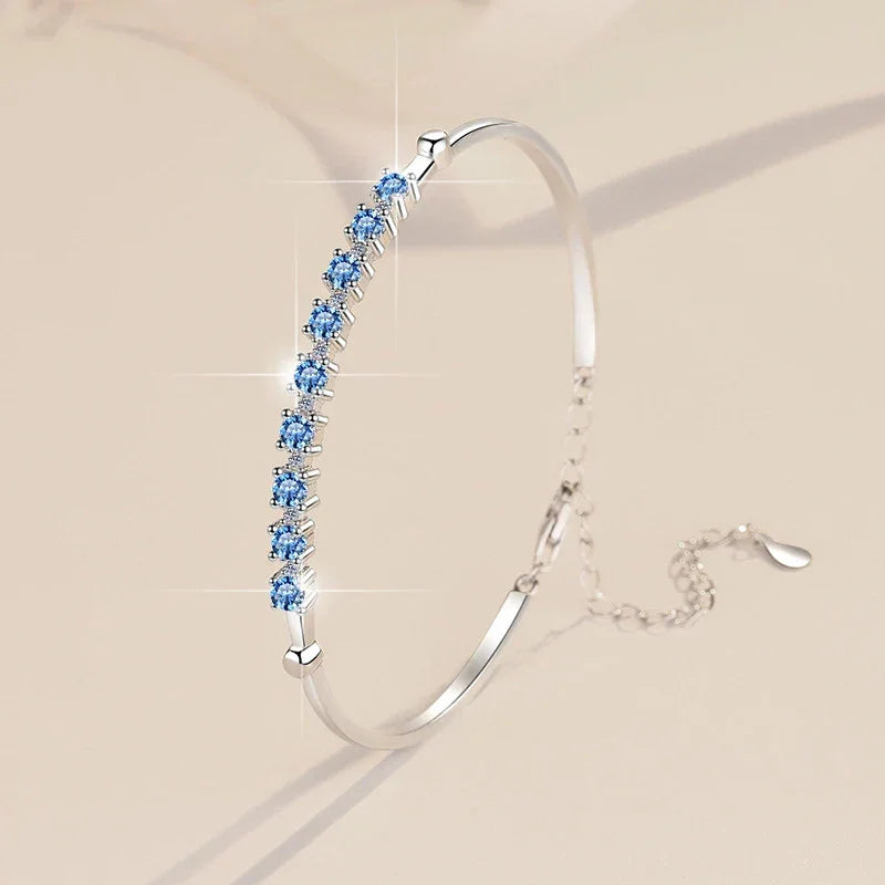 Silver bracelet with blue gemstones on a beige background