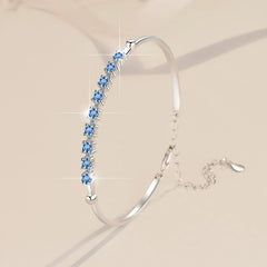 Silver bracelet with blue gemstones on a beige background