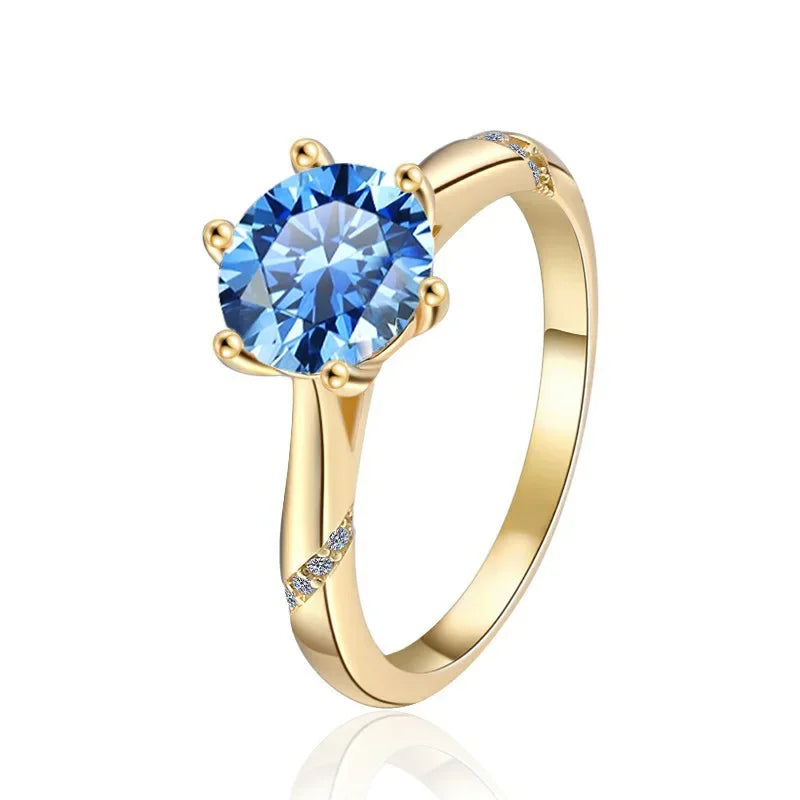 Gold ring with a blue gemstone on a white background