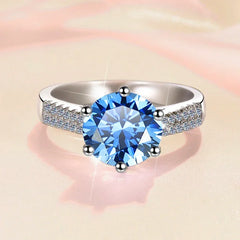 Silver ring with a blue gemstone on a soft pink background