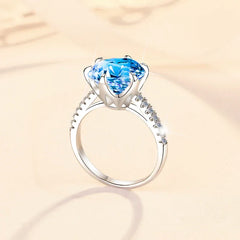 Silver ring with a blue gemstone on a beige background