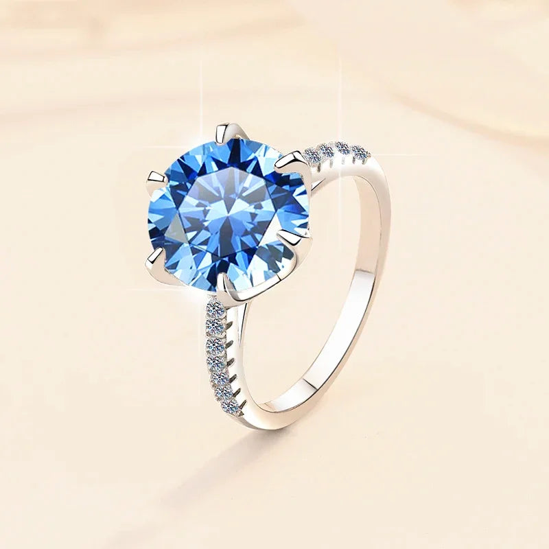 Silver ring with a large blue gemstone on a beige background