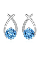 Pair of silver earrings with blue gemstones on a white background