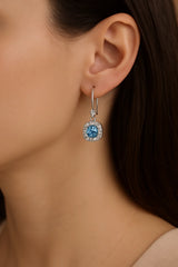 Close-up of a person wearing a blue gemstone earring.