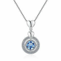 Silver necklace with a heart pendant and blue gemstone on a white background