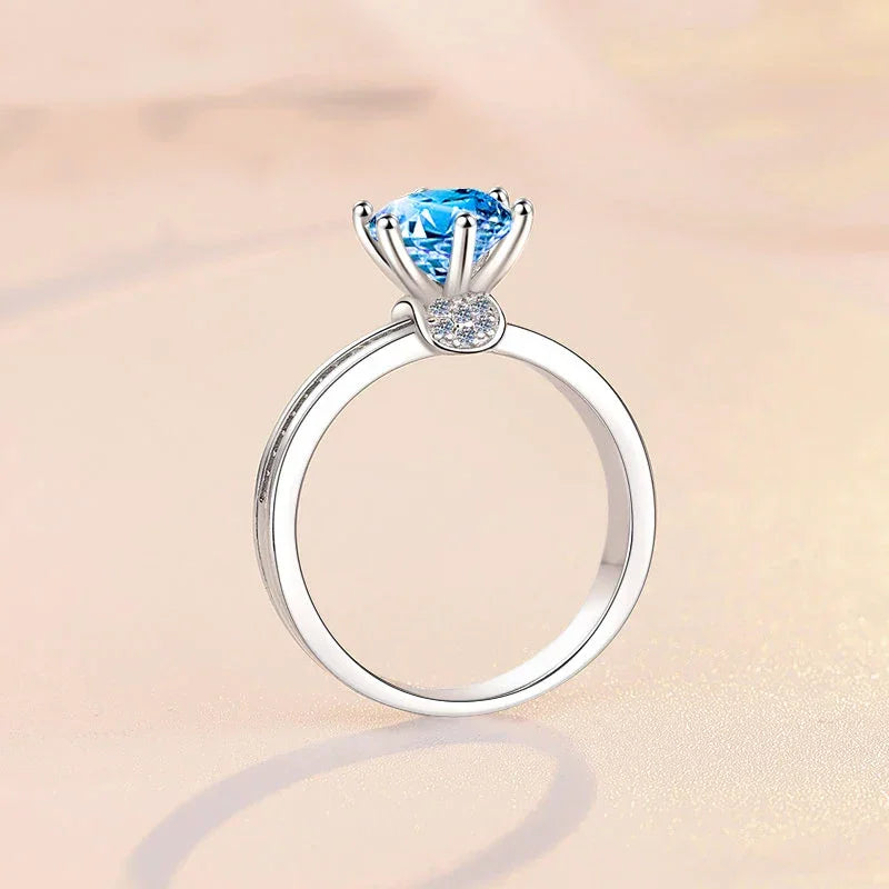Silver ring with a blue gemstone on a beige background
