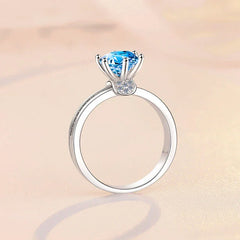 Silver ring with a blue gemstone on a beige background