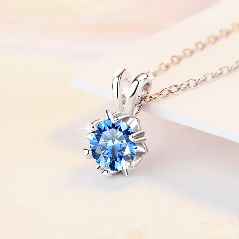 Silver necklace with a blue gemstone pendant on a light background