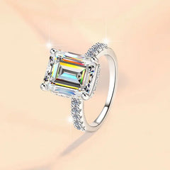 Silver ring with a large gemstone on a soft pink background