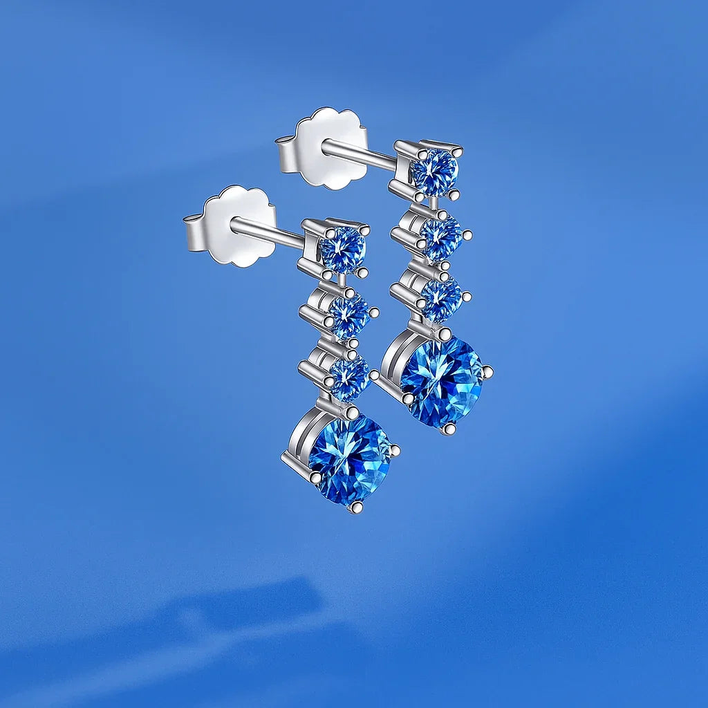 Silver earrings with blue gemstones on a blue background