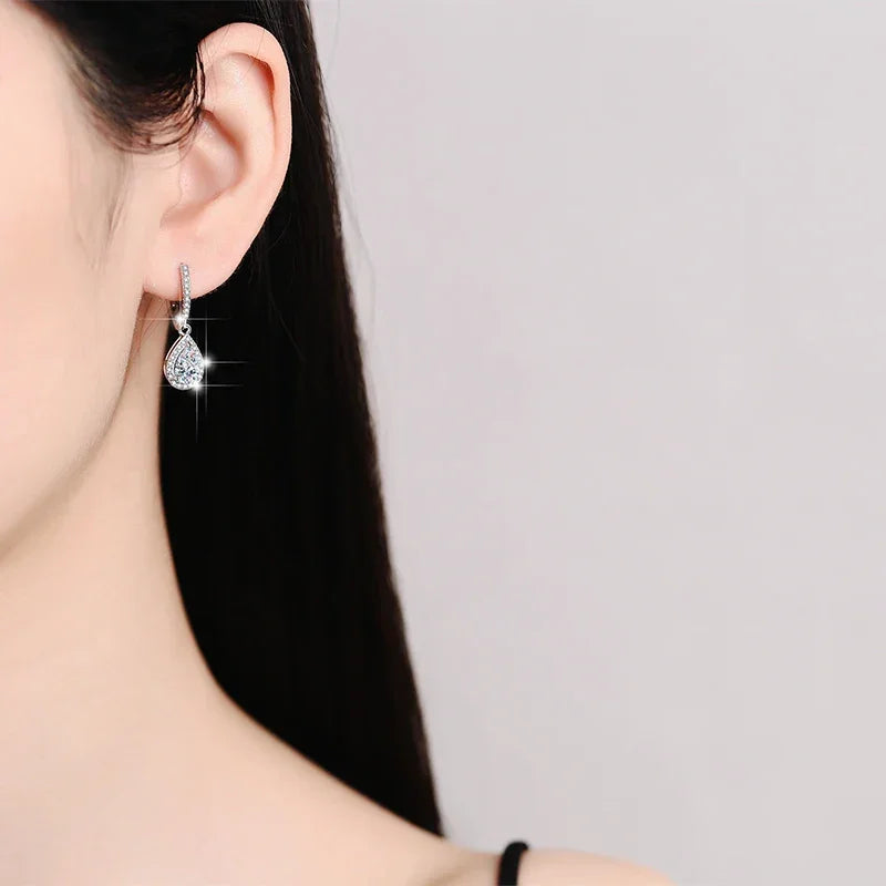 Heart-shaped earring worn by a person with a neutral background
