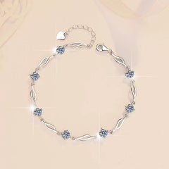 Silver bracelet with heart-shaped crystals on a beige background
